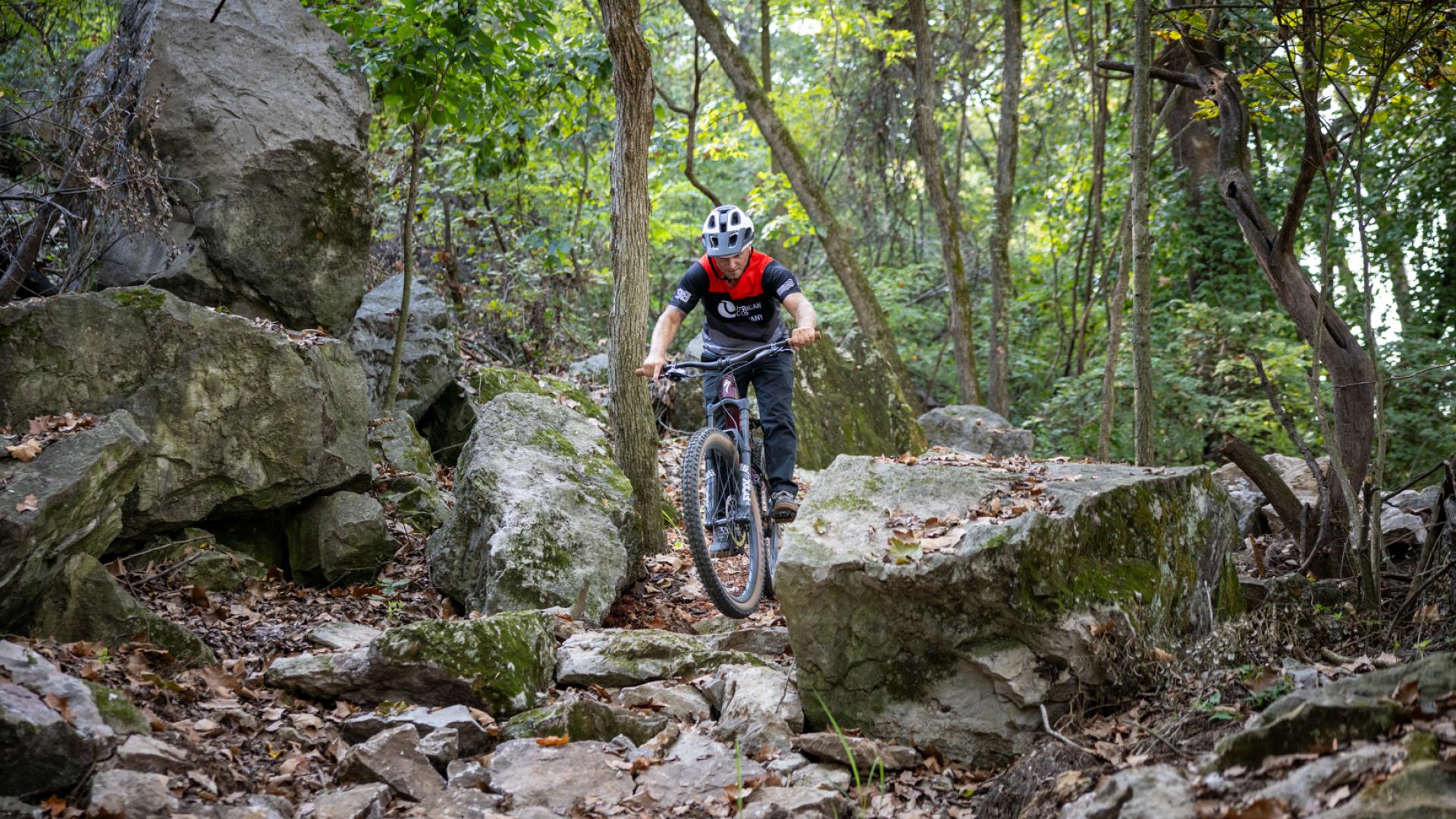 Mountain biker navigating between boulders at MOmentum