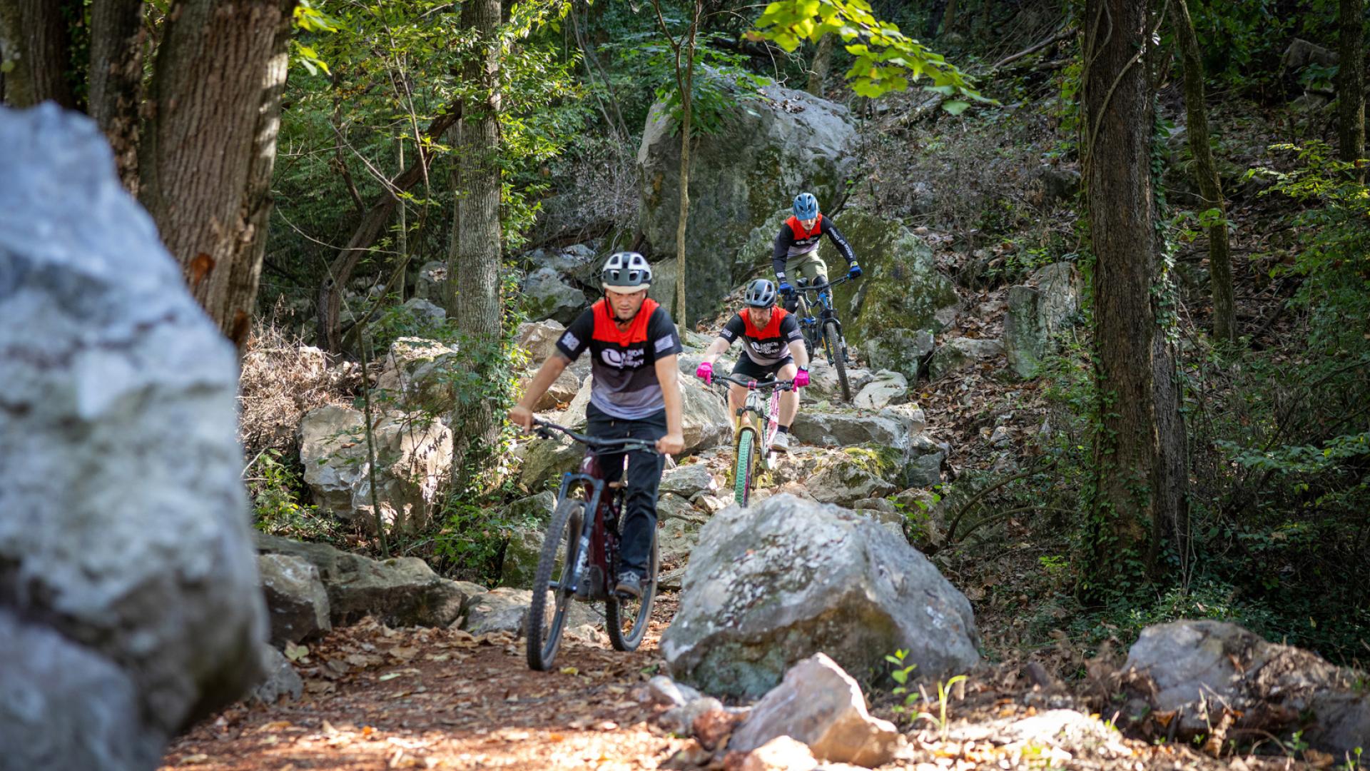 Three bikes riding on a mountain biking trail