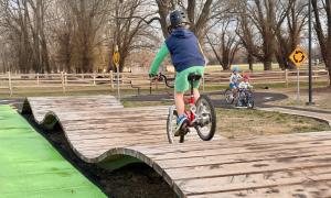 Kid riding bike on "Triple Nessy" feature