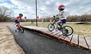 kids on bikes with training wheels in the bicycle playground